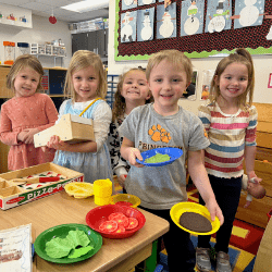 Happy children showing off projects at preschool